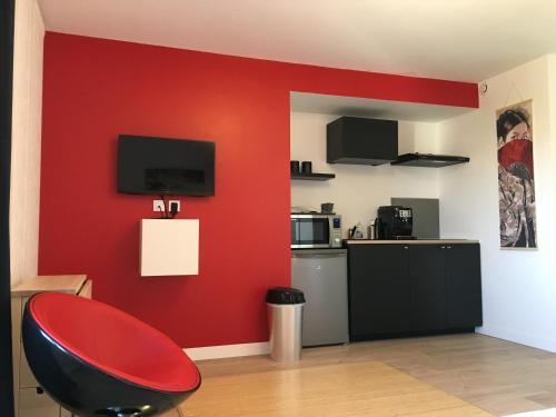 une chambre rouge avec un mur rouge et une chaise rouge dans l'établissement Le Fuji centre la Brèche wifi calme vue jardin, à Niort