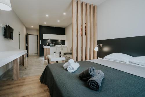een slaapkamer met een groot bed en handdoeken bij Unique Experience Apartment’s in Thessaloniki