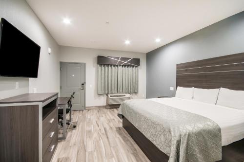 a hotel room with a bed and a flat screen tv at Americas Best Value Inn & Suites Northeast Houston Downtown I-610 in Houston