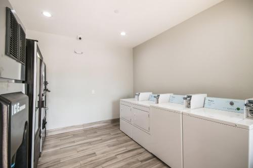 ヒューストンにあるAmericas Best Value Inn & Suites NE Houston Downtown I-610の洗濯機、乾燥機が並ぶランドリールーム