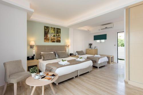 a hotel room with a bed and a couch and a table at Melina Bay Boutique Hotel in Kassiopi