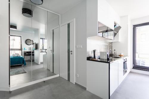 een keuken met witte muren en een glazen wand bij Luxury Apartment with Large Terrace in Wrocław
