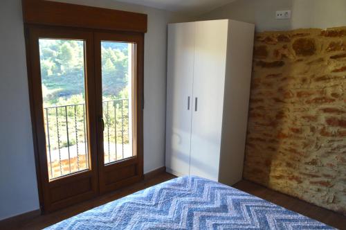 um quarto com uma cama e uma grande janela em Casa Cerrito em Cortes de Arenoso