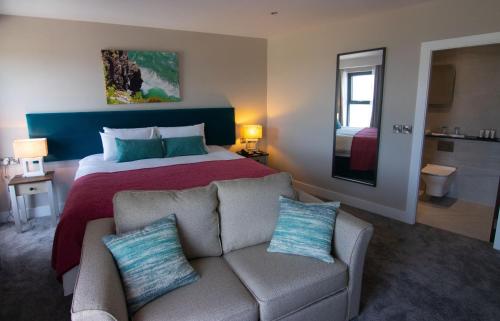 ein Hotelzimmer mit einem Bett und einem Sofa in der Unterkunft The Marine Boutique Hotel in Ballybunion