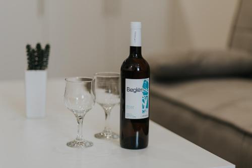 a bottle of wine next to two glasses on a table at Unique Experience Apartment’s in Thessaloniki