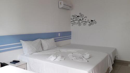 a white bed with two white towels on it at Hotel Ponta de Areia in Porto Seguro