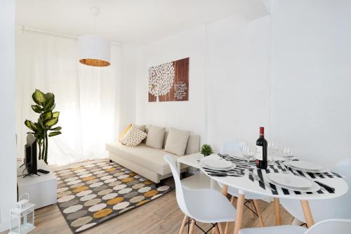 a white living room with a table and a white couch at La Casa De Esme ll in Haro
