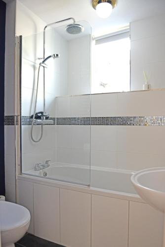y baño con ducha, bañera y lavamanos. en Cathedral View Apartment, Flat 3, en Bury Saint Edmunds