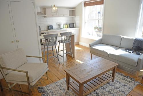 ein Wohnzimmer mit einem Sofa, Stühlen und einem Tisch in der Unterkunft Cathedral View Apartment, Flat 3 in Bury Saint Edmunds
