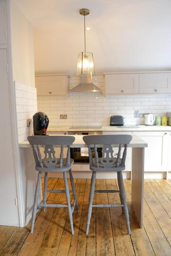 uma cozinha com uma mesa e dois bancos em Cathedral View Apartment, Flat 3 em Bury Saint Edmunds