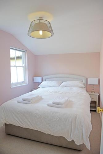 a bedroom with a white bed with two towels on it at Cathedral View Apartment, Flat 3 in Bury Saint Edmunds