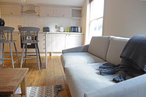 a living room with a couch and a kitchen at Cathedral View Apartment, Flat 3 in Bury Saint Edmunds