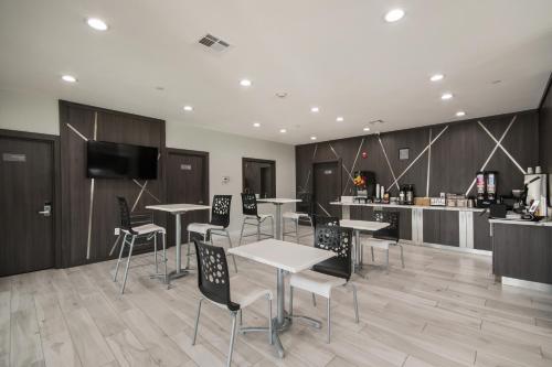 a room with tables and chairs and a kitchen at Americas Best Value Inn & Suites Northeast Houston Downtown I-610 in Houston