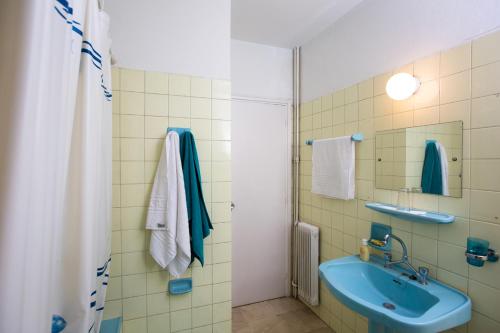 a bathroom with a blue sink and a shower at Christina's flat in Athens