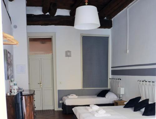 a hotel room with two beds and a window at La Maison in Bergamo