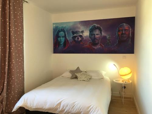 une chambre avec un lit avec un tableau sur le mur dans l'établissement Le Galaxy centre la Brèche wifi calme vue jardin, à Niort