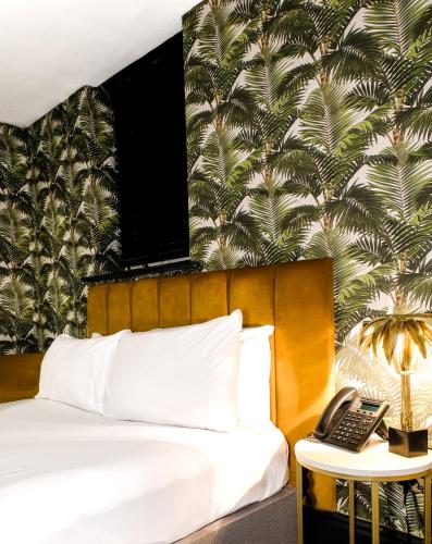 a bedroom with a bed with a phone on a table at Lock and Key Boutique Hotel - Duke Street in Liverpool