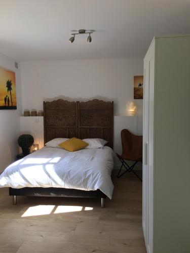 une chambre avec un grand lit et une chaise dans l'établissement Le Sirocco centre la Brèche wifi linge de pressing, à Niort
