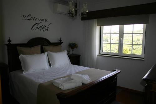 a bedroom with a bed with towels on it at Quinta das Murtinheiras in Lamego