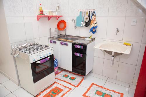 una pequeña cocina con fogones y fregadero en Conforto Total - Família Mangas Monteiro en Macapá
