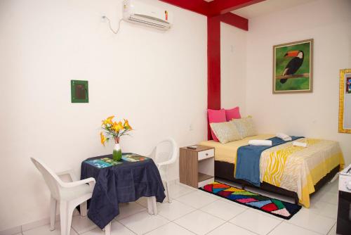 a bedroom with a bed and a table and chairs at Conforto Total - Família Mangas Monteiro in Macapá