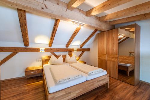 een slaapkamer met een bed in een kamer met houten plafonds bij Gasthaus Traube in Bichlbach