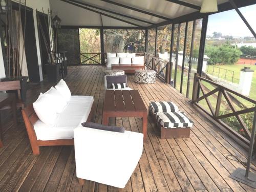 a porch with couches and chairs on a wooden deck at San Isidro Hotel in Mercedes