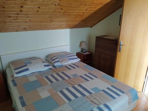 a bedroom with a bed and a wooden ceiling at Captain Apartments in Vinišće