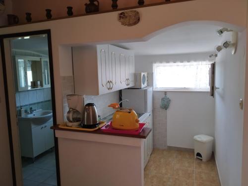 a kitchen with a counter with a yellow appliance on it at Captain Apartments in Vinišće