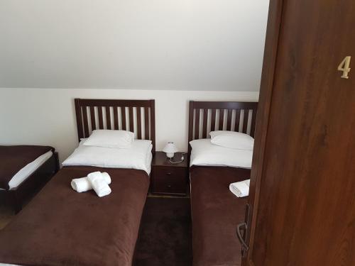 two beds in a small room with towels on them at Duna Dráva Vendégház in Érsekcsanád