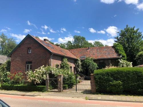 ein Backsteinhaus mit einem Zaun davor in der Unterkunft Holiday home Elena in Slenaken