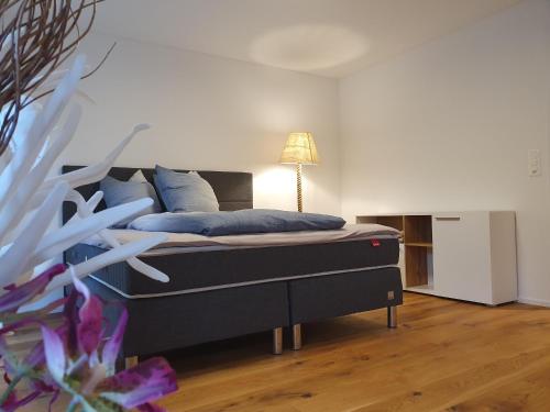 a bedroom with a bed with blue pillows and a lamp at Wohnstation in Subingen