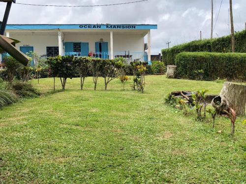 un jardin en face d'un bâtiment dans l'établissement OCEAN-SI MAnsion, à Kribi