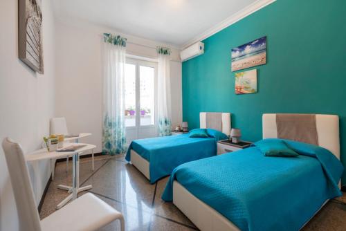 een blauwe slaapkamer met 2 bedden en een tafel bij Dream House spazioso appartamento tra Policlinico e Piazza Bologna in Rome