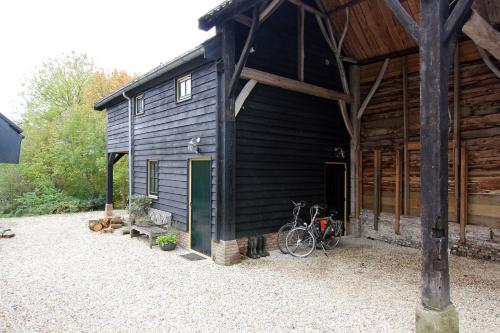 a black barn with a bike parked outside of it at B&B de Linge in Gellicum