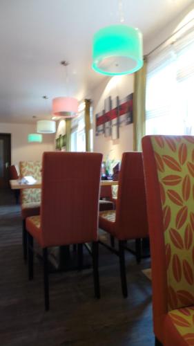 a dining room with chairs and a table and a blue light at Rhönblick Landhotel - Restaurant - Countrypub in Petersberg