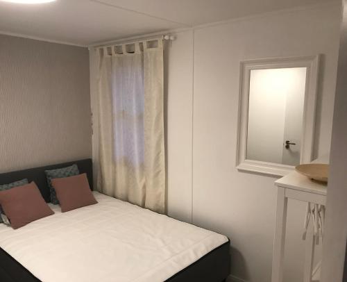 een klein bed in een kamer met een raam bij Aranypart Apartmanházak Tiszakécske in Tiszakécske