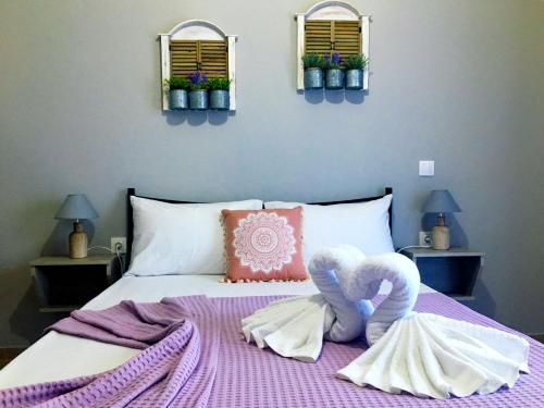 a bedroom with a bed with two towels on it at Almira - rooms to let in Nea Roda