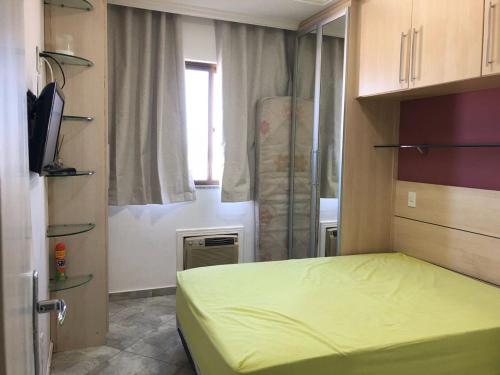 a small bedroom with a bed and a window at FORTE DA PRAIA 2 in Cabo Frio
