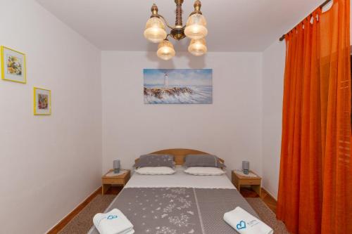 ein Schlafzimmer mit einem Bett und einem Kronleuchter in der Unterkunft Apartman Zorica in Biograd na Moru