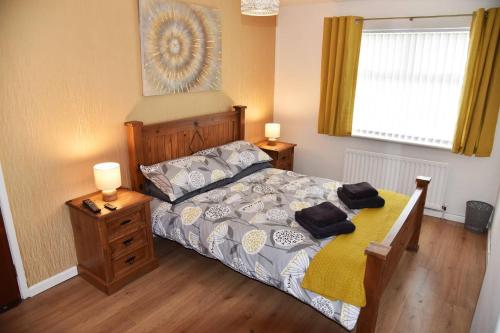 een slaapkamer met een bed, 2 lampen en een raam bij ADAIR HOUSE in Ballymena