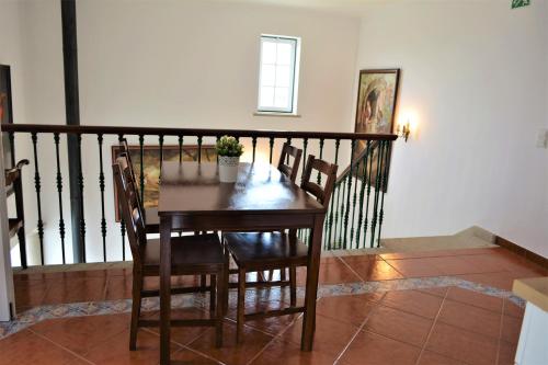 a wooden table and chairs in a room at Casal dos Cantos in Quinta do Anjo