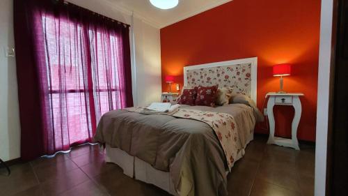 a bedroom with a bed with red walls and windows at Apartamento 4 de Enero in Santa Fe