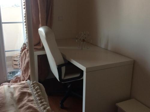 a desk with a chair next to a bed at Sunny Suites Golf and Free Parking Guest House in Lisbon