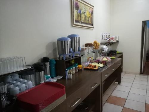 a kitchen with a counter with food on it at Hotel Figueira Palace in Dourados