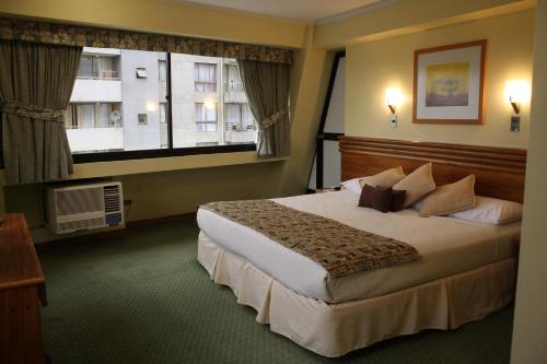 a hotel room with a large bed and a window at Gala Hotel in Viña del Mar