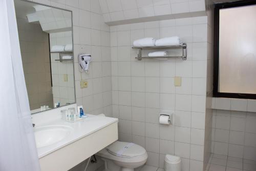 a bathroom with a sink and a toilet and a mirror at Gala Hotel in Viña del Mar