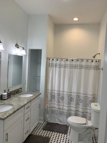 a bathroom with a toilet and two sinks and a shower at New Orleans Home Sweet Home in New Orleans