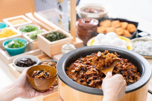 a person eating a bowl of food with a spoon at Vessel Inn Sakae Station in Nagoya