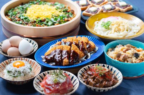 a table with plates of food and bowls of food at Vessel Hotel Campana Nagoya in Nagoya